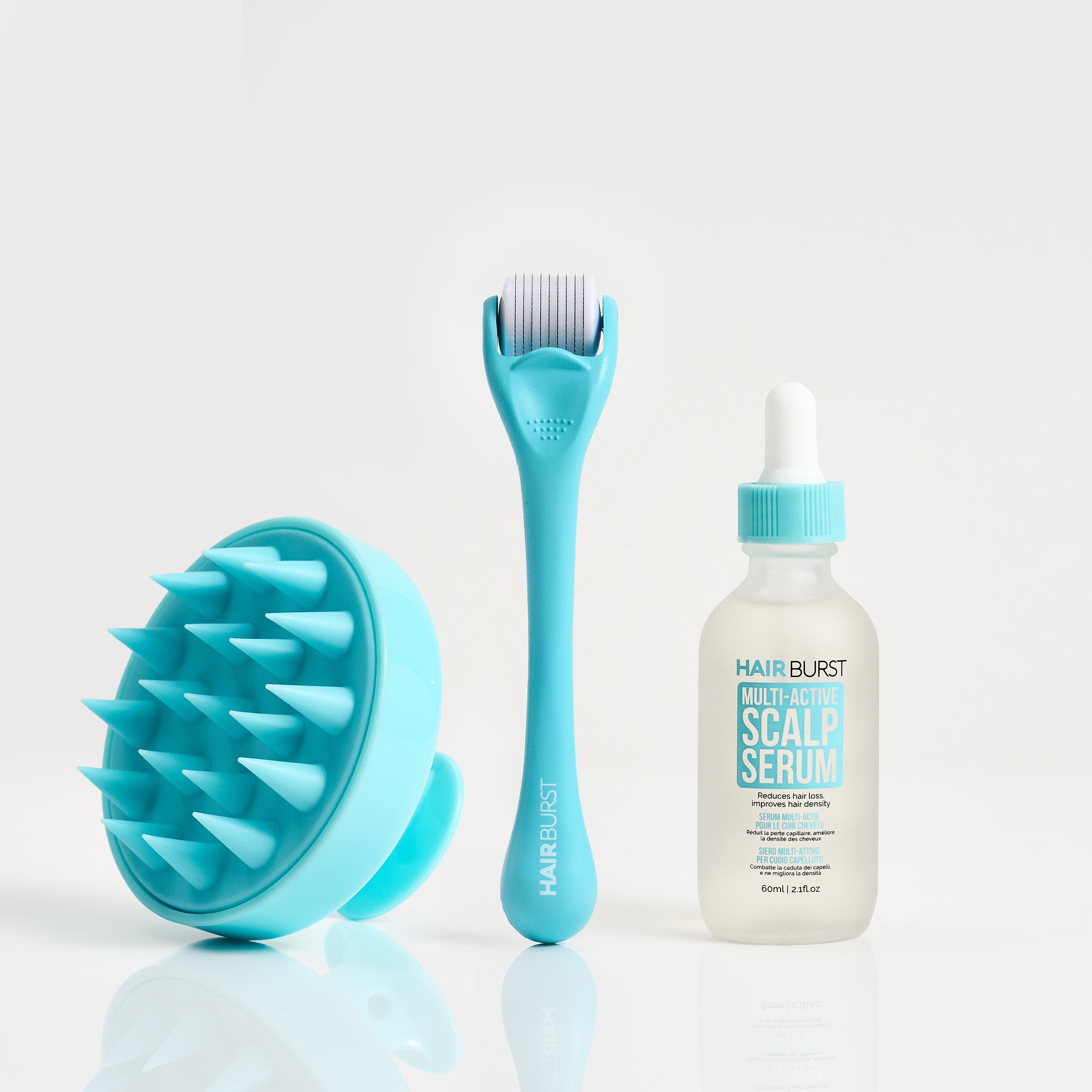 Turquoise scalp brush, roller, and bottle of scalp serum on a white background